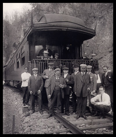 The Virginian Railway's owners and officials posed on the rear platform of a private car in a mountain rock cut